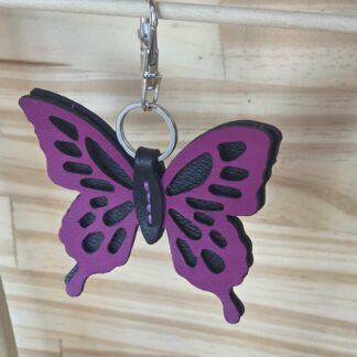 Porte clé papillon fushia cousu sur fond noir
