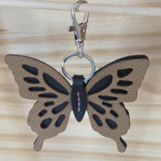 Porte clé papillon camel cousu sur fond noir